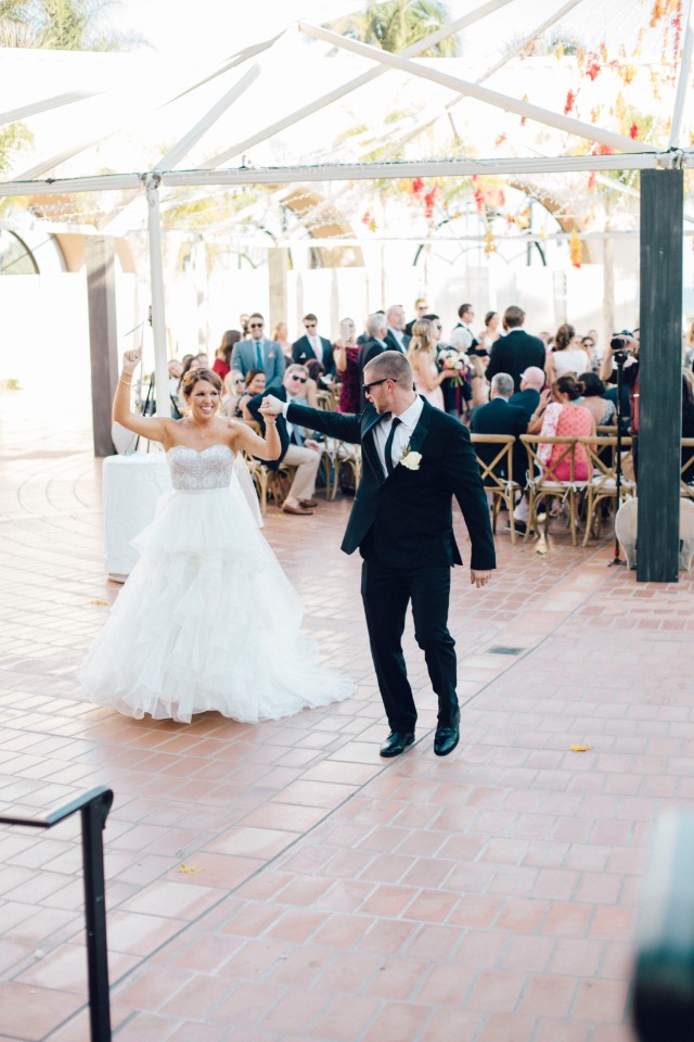 Excited bride and groom celebrating at their outdoor wedding