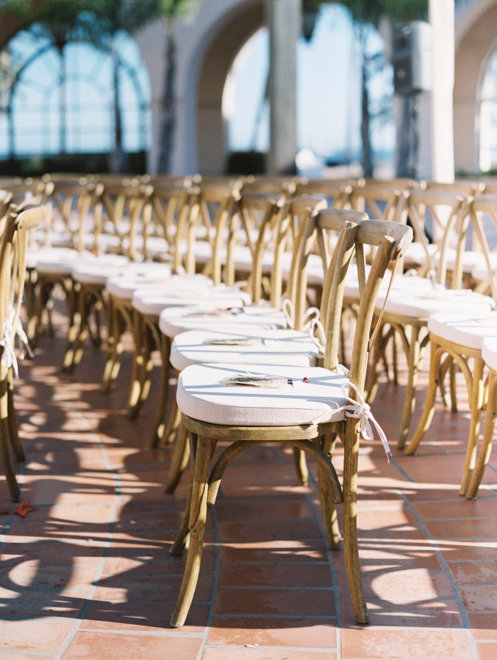 Empty chairs set for a wedding ceremony at a sunny outdoor location