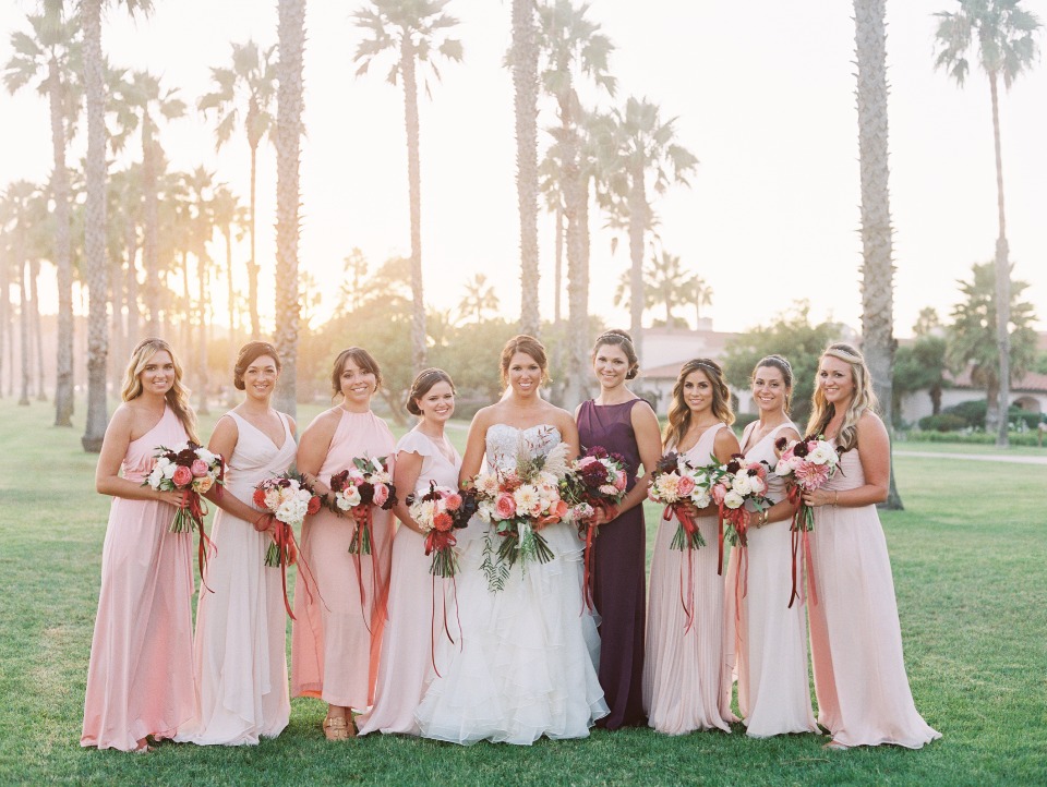 Bride and bridesmaids in pink gowns, sunset wedding