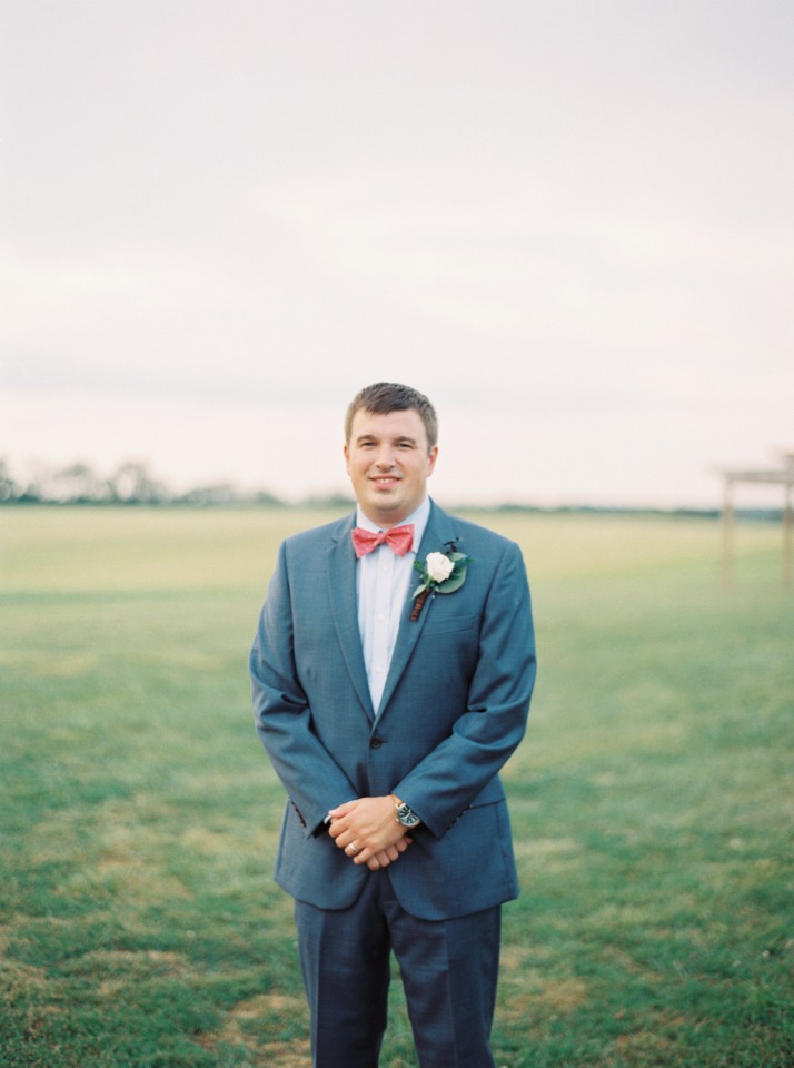 groom in blue with red bow tie