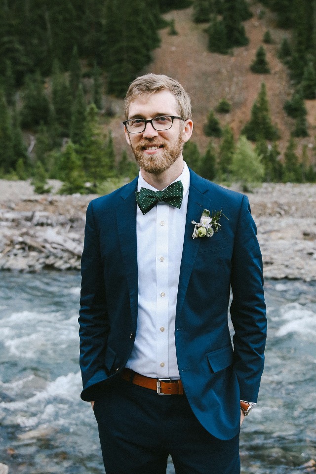 groom in blue suit and forest green bow tie