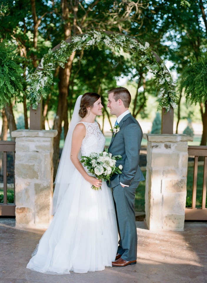 Bride and groom smile during outdoor wedding ceremony