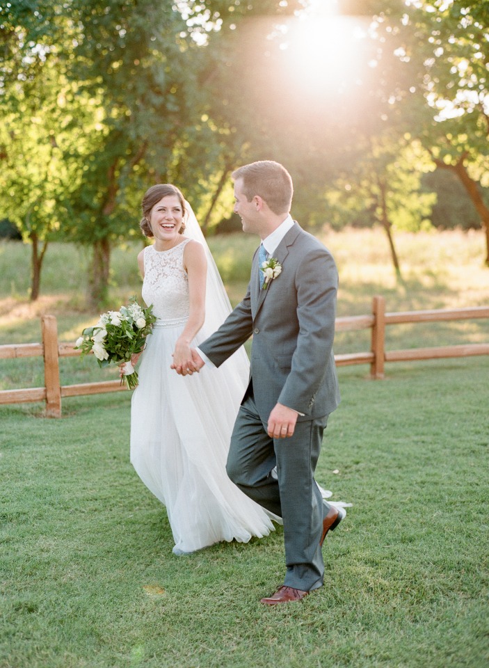Happy bride and groom walking in a sunny outdoor wedding