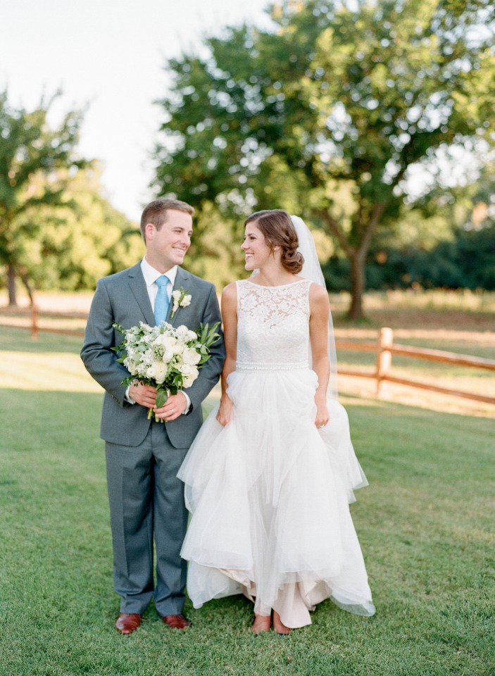 Happy bride and groom smile at each other on wedding day
