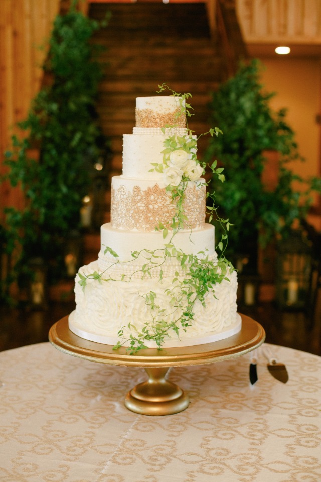 Gold and white wedding cake with green garland