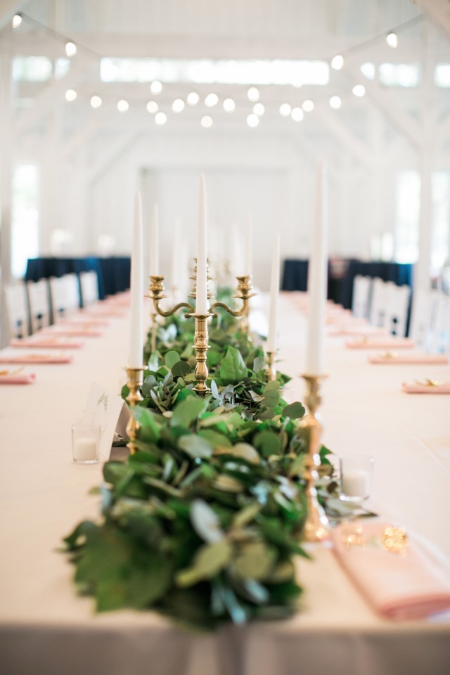 family style seating with long garland and gold candle stick centerpiece