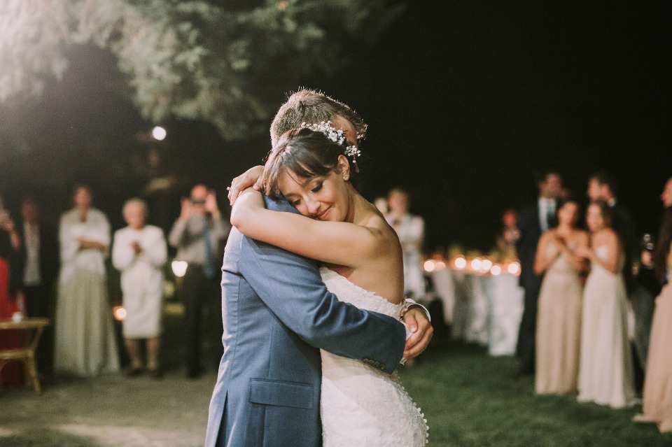 Bride and groom share a tender hug during their wedding dance