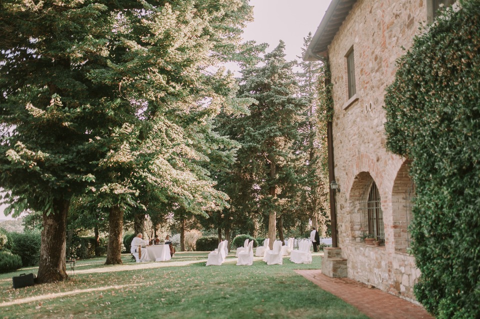 Wedding ceremony set up in a beautiful garden with a stone building