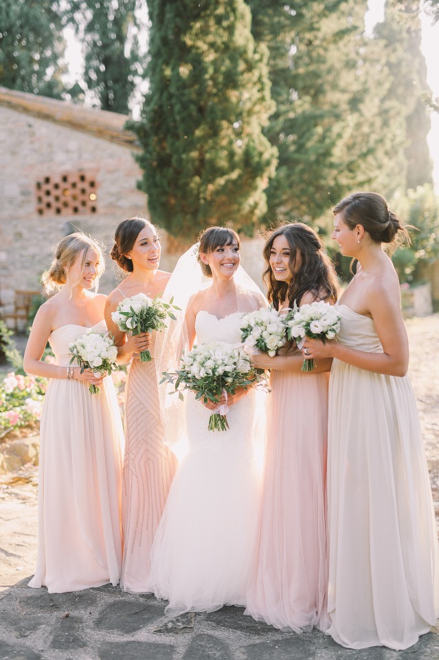 Bride and bridesmaids in blush dresses holding bouquets