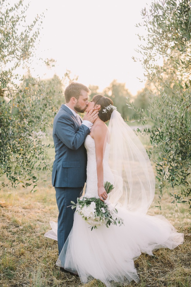Bride and groom share a kiss on their wedding day outdoors