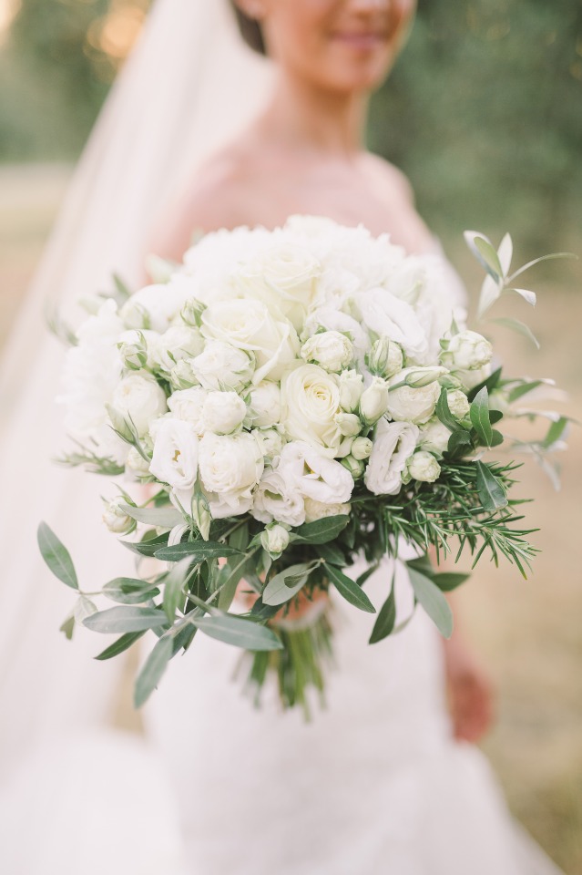 Bride holding an elegant white rose wedding bouquet