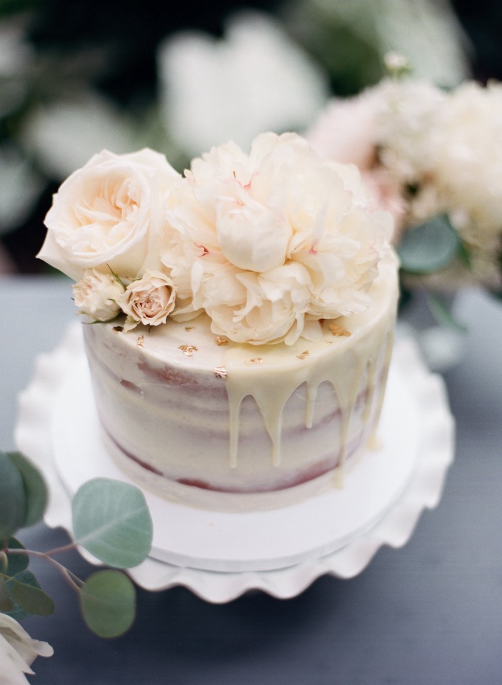 Elegant wedding cake with roses and creamy drip frosting