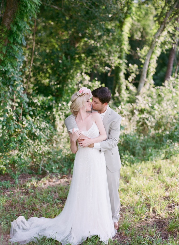 Romantic wedding couple kissing in a forest setting