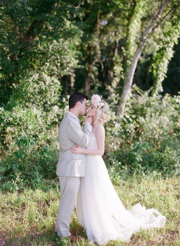 Newlyweds share a kiss in a dreamy forest wedding scene