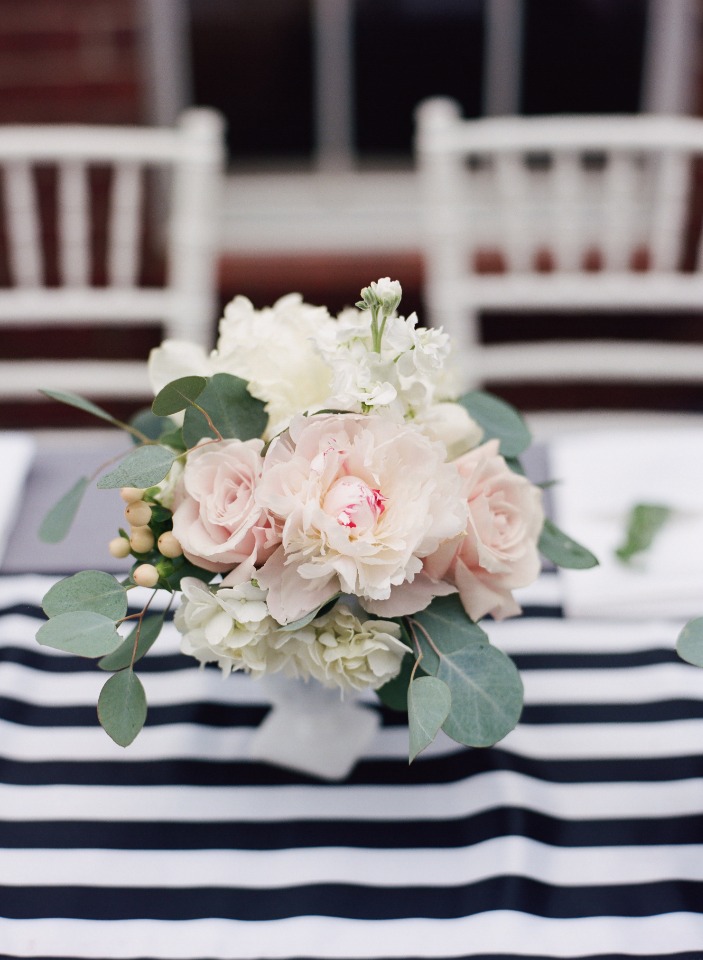 Elegant floral centerpiece with roses on striped tablecloth