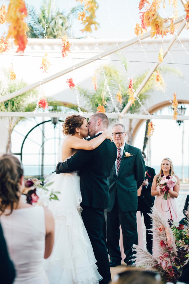 Bride and groom share a kiss at their wedding ceremony