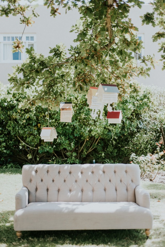 Photo booth with vintage couch and hanging books