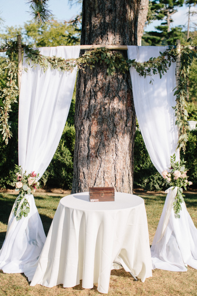 draped wedding ceremony backdrop with floral garland