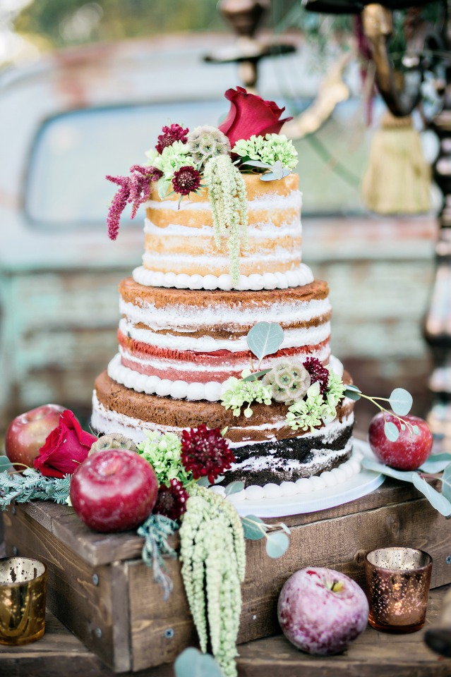 naked wedding cake topped by flowers