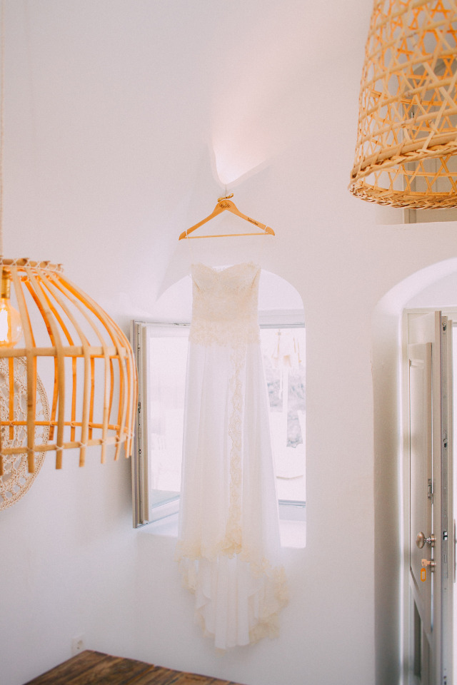 White wedding dress hanging in a bright airy space