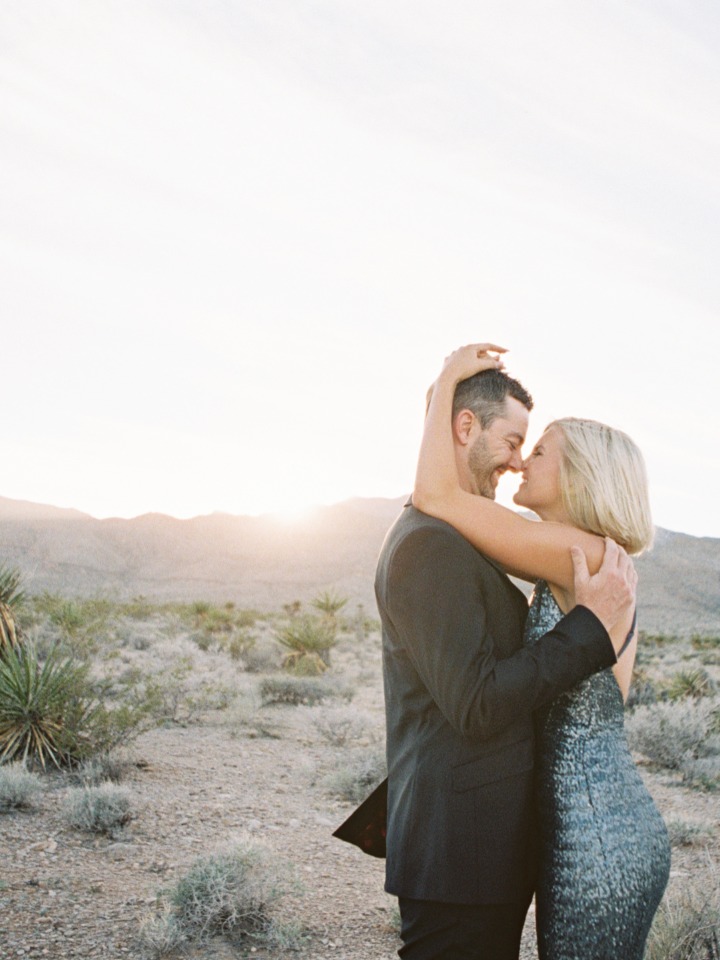Couple embrace in desert landscape, golden hour romance