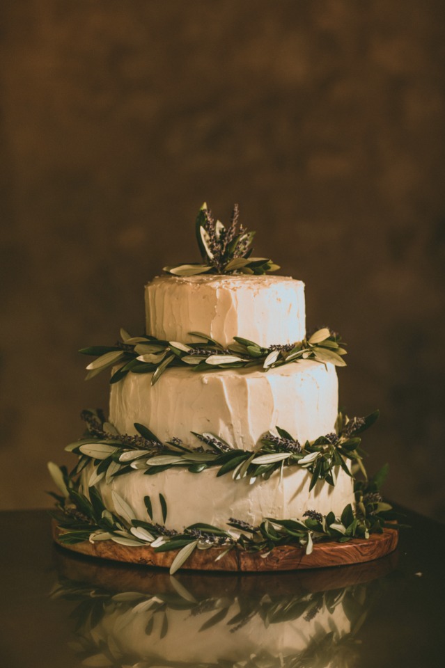 wedding cake topped with olive branches and lavender