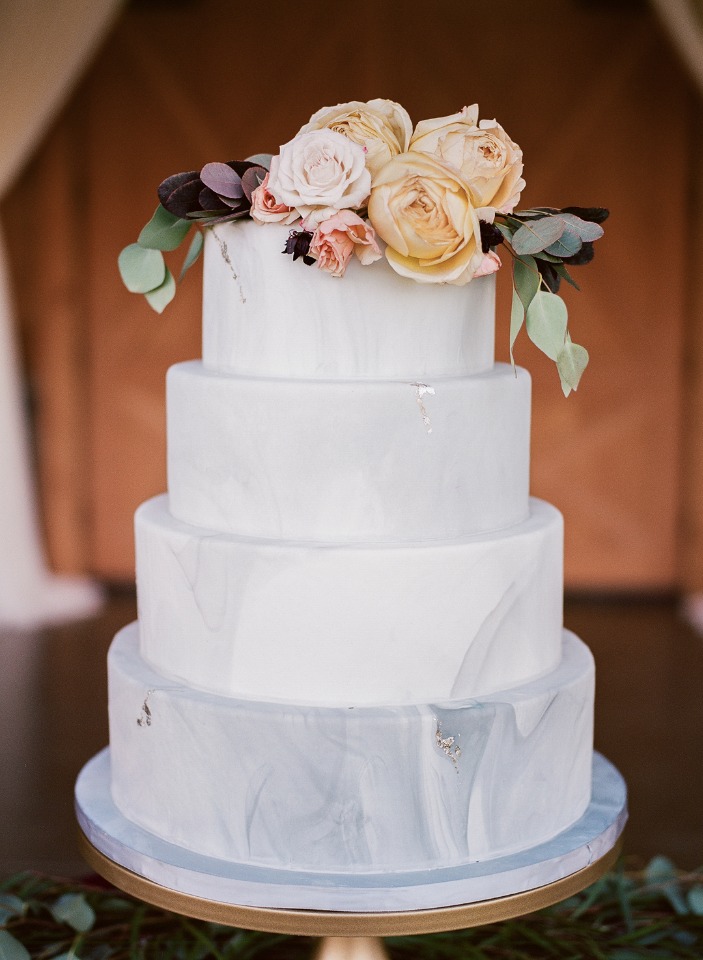 Elegant four-tiered wedding cake with floral topping