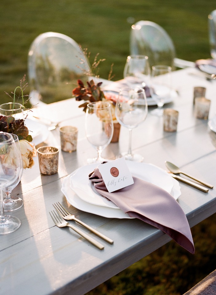 Elegant outdoor wedding table setting with floral centerpiece and place card