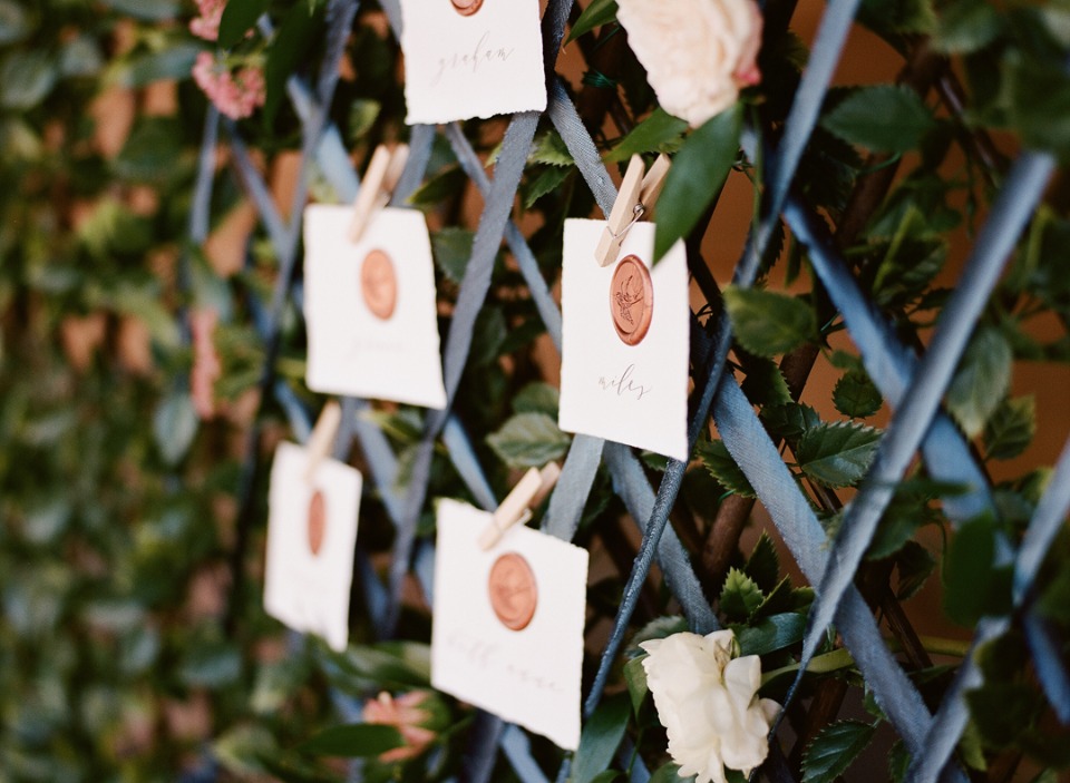 Wedding seating chart with wax sealed cards on trellis