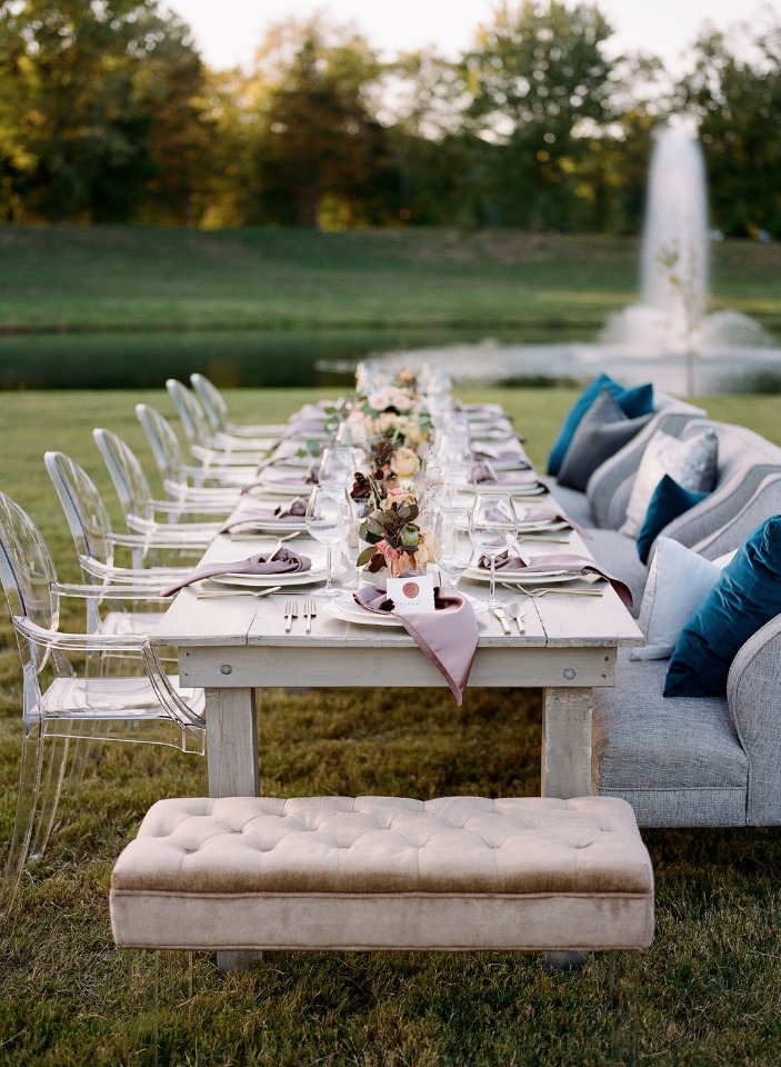 Outdoor elegant dinner table set up in a green field