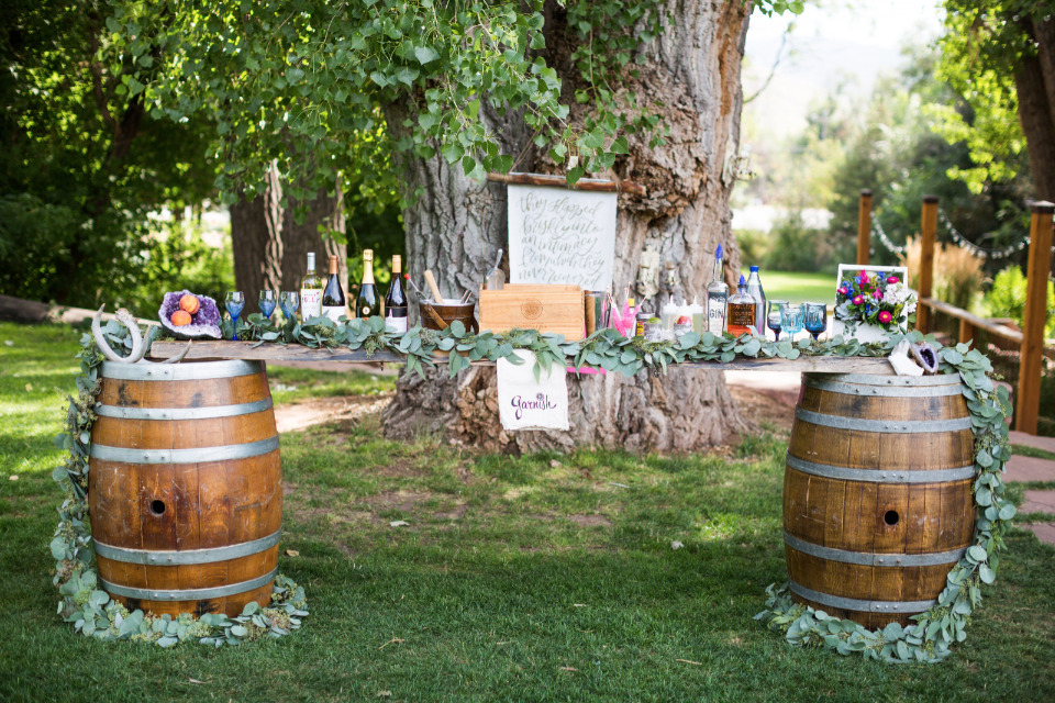 flower covered wedding bar with whiskey barrels