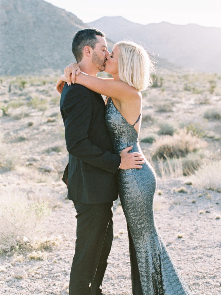 Couple sharing a kiss on a desert landscape, wedding photoshoot