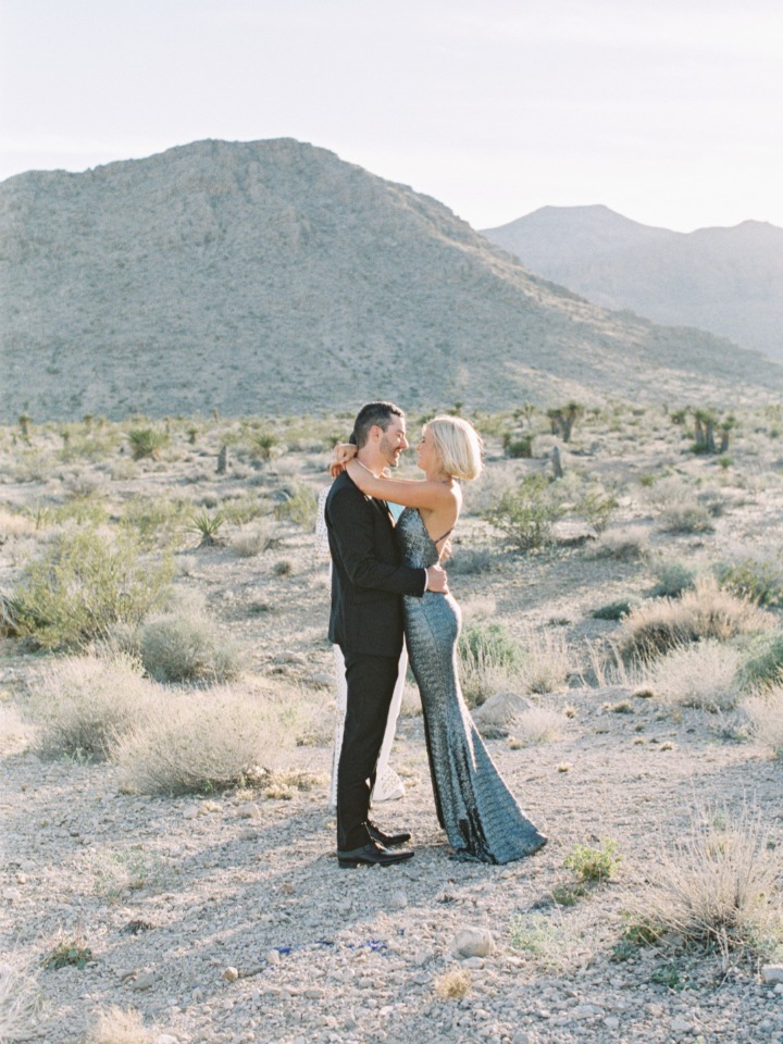 Romantic couple embraces in desert landscape, wedding photography