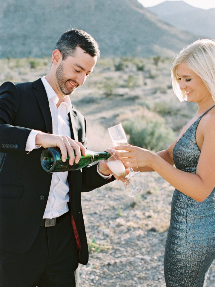 Couple celebrating with champagne outdoors in a sunny location