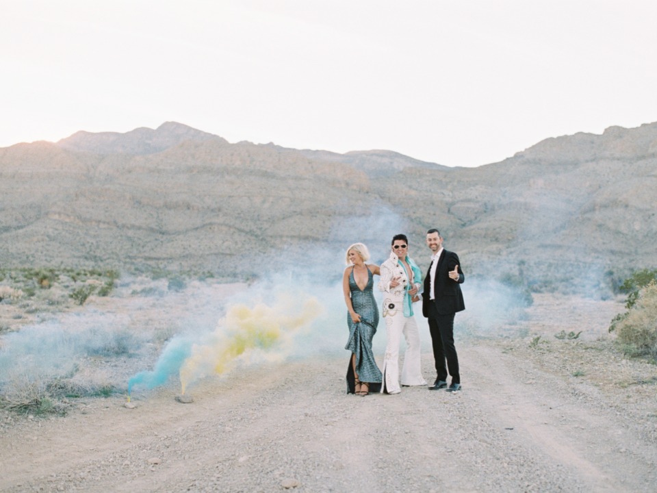 Group posing with Elvis impersonator on a desert road