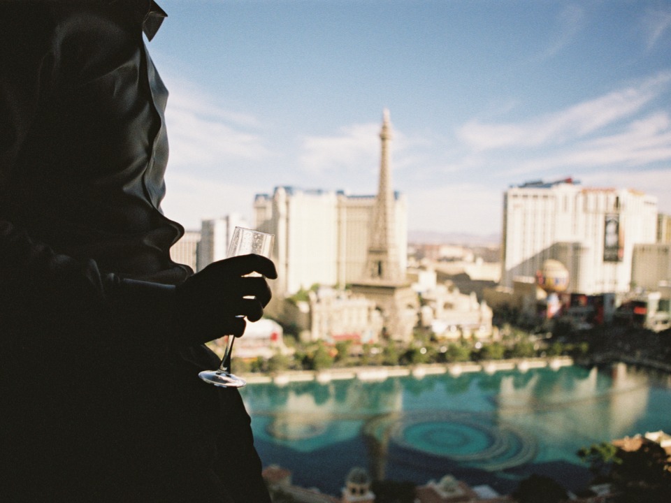 Person with champagne glass overlooking Las Vegas skyline