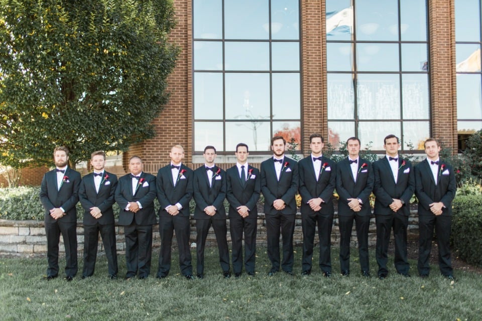 tuxedo groom and groomsmen with burgundy boutonnieres
