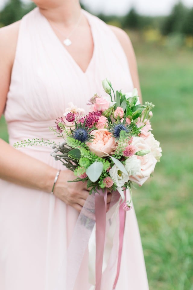 bridesmaid bouquet in peach and pink with blue thistle