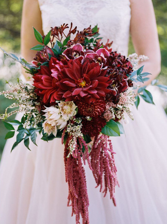 Bride holds deep red dahlia wedding bouquet flowers
