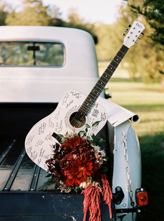 White acoustic guitar guestbook with wedding flowers