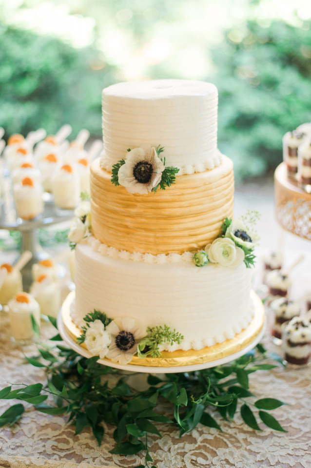 gold and white wedding cake with anemones