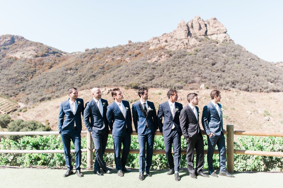 groomsmen in mismatched blue and grey suits