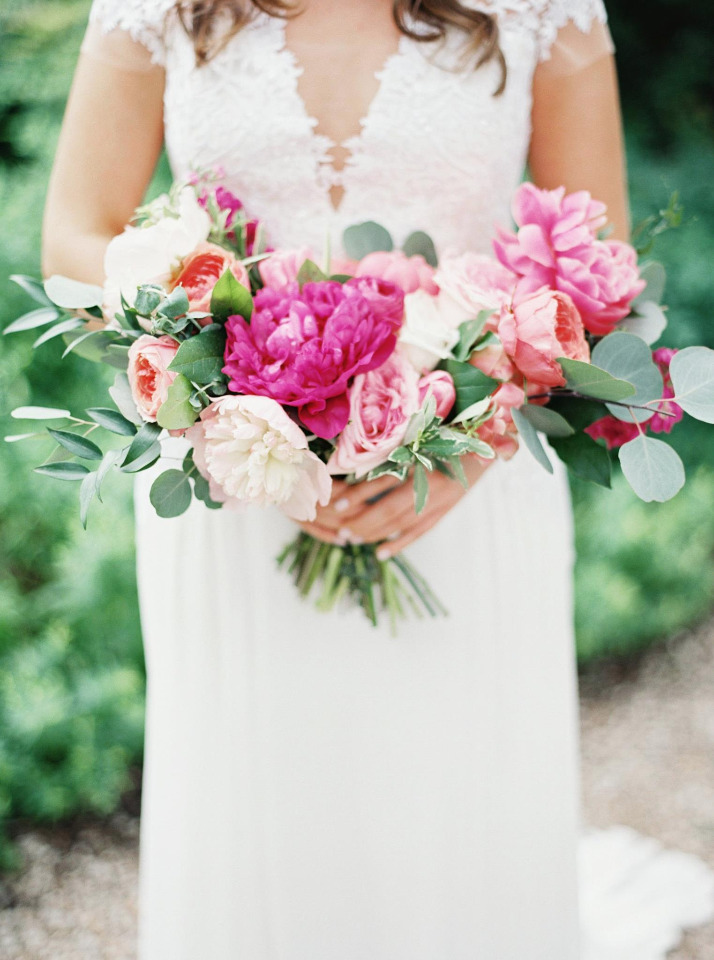 Bride holds pink and peach wedding bouquet flowers