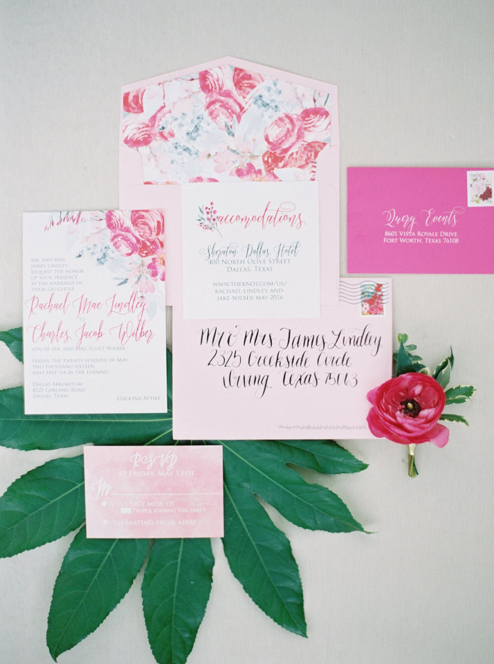 Elegant pink floral wedding invitation suite on green leaves