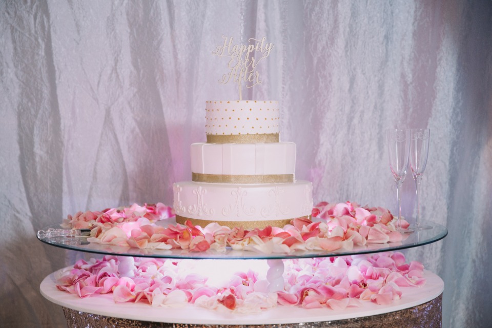 White and gold cake with pink rose petals