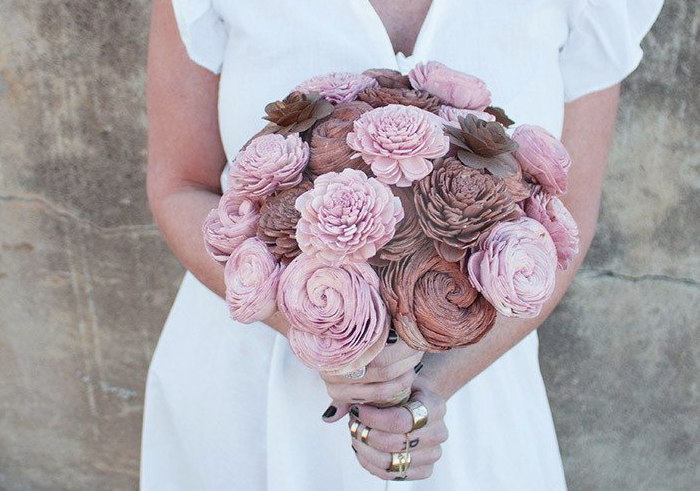 Bride holding a beautiful bouquet of mauve and brown wooden flowers