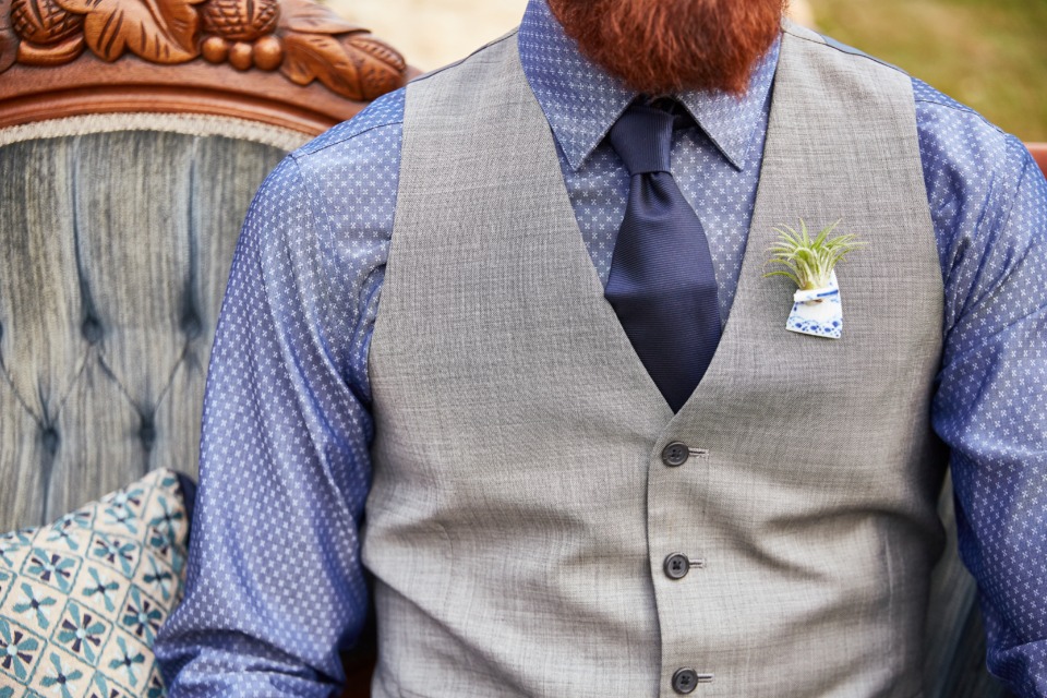 blue and grey groom look with unique hair plant boutonniere
