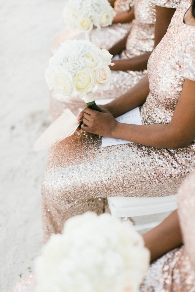 bridesmaids in rose gold sequin dresses with white bouquets