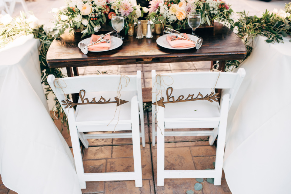 Romantic wedding table decor with his and hers signs on chairs