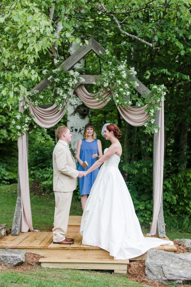 beautiful draped wedding ceremony backdrop with flowers